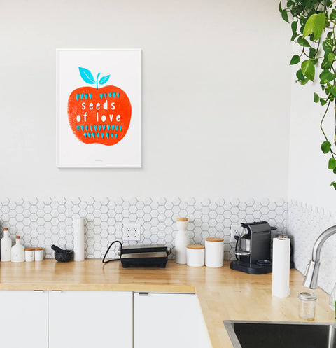 Red apple illustration poster in a modern white kitchen.