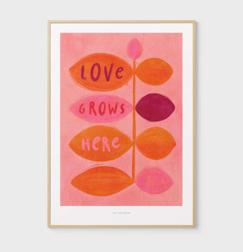 Illustration art print features a bold flower, paired with the inspiring quote "love grows here"