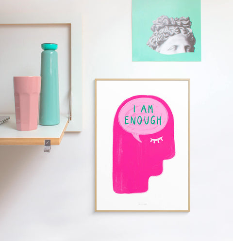 Pink graphic illustration wall art featuring a big head with a speech bubble saying I am enough.