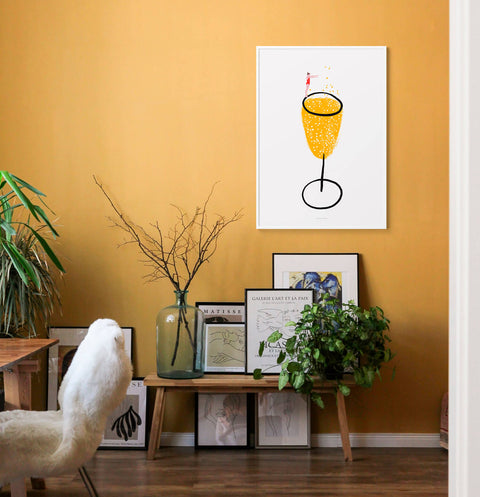 Champagne glass illustration wall art print hanging on yellow wall in living room.