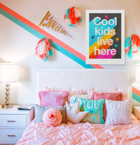 The phrase "Cool kids live here" is hand-lettered with vibrant colors, bold typography and retro look. Hanging in fun, colorful, modern and contemporary nursery room for girls. Cool kids posters.