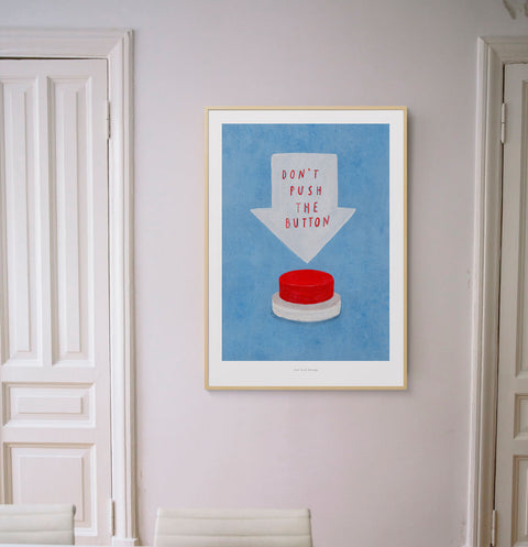 Don't push the button funny wall art. Illustration of a big red button and hand painted typography quote saying "don't push the button", hanging in a minimalist white interior decor.