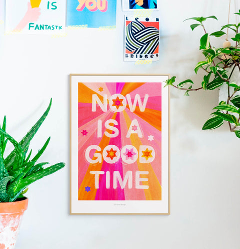 Typography poster about mindfulness featuring hand lettered quote saying "now is a good time" with warm color palette in pink and yellow.